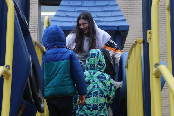 Sophomore Minela Spahija joins preschoolers on the playground bridge.