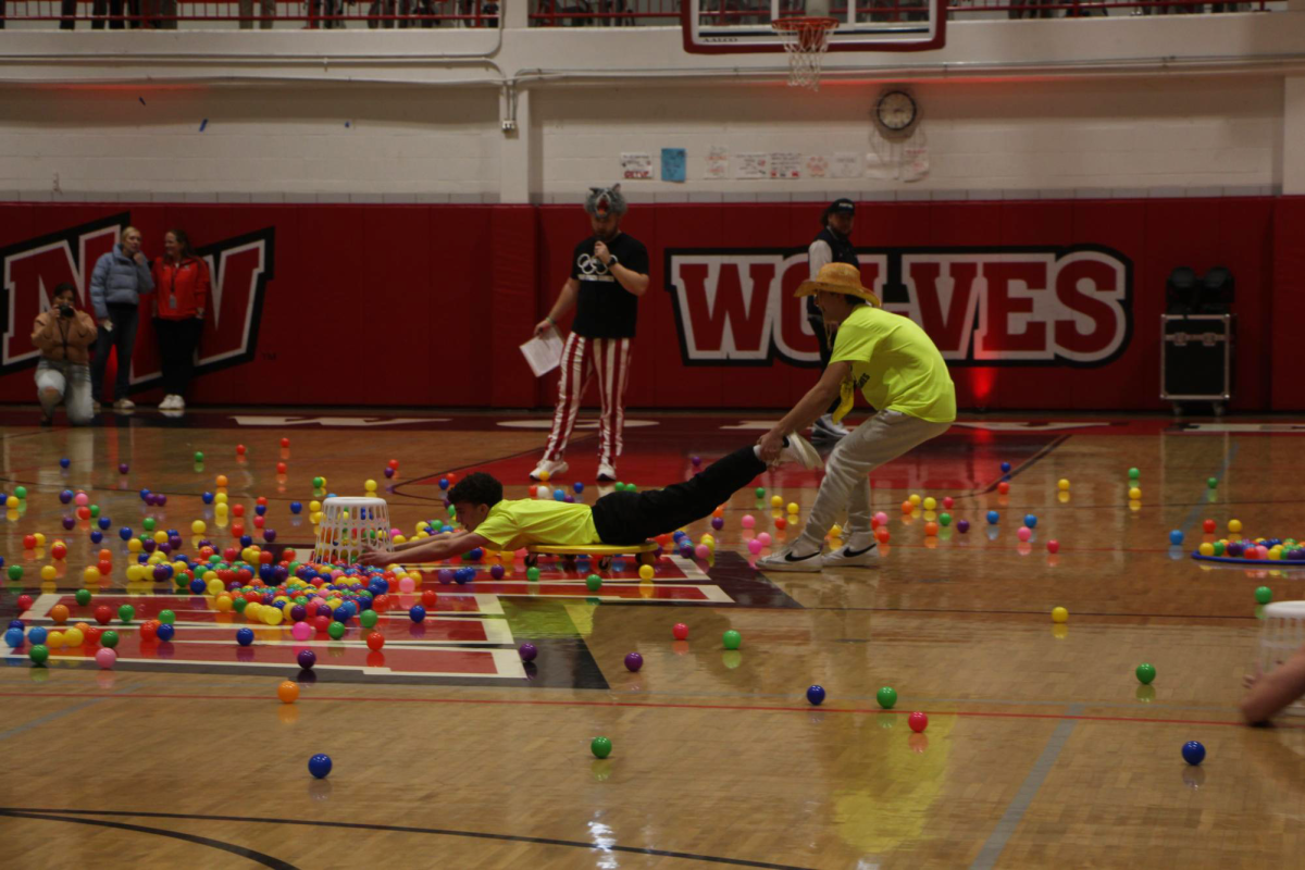 Sophomore Athan Frake drags sophomore Michael Atsaves during the game "human hungry, hungry hippo". Atsaves uses a laundry hamper to drag in as many plastic balls as possible, to place in the hoola-hoop ring to be counted at the end of the game. The team with the most plastic balls at the end of the three minutes wins the game, adding 20 points to their total score.