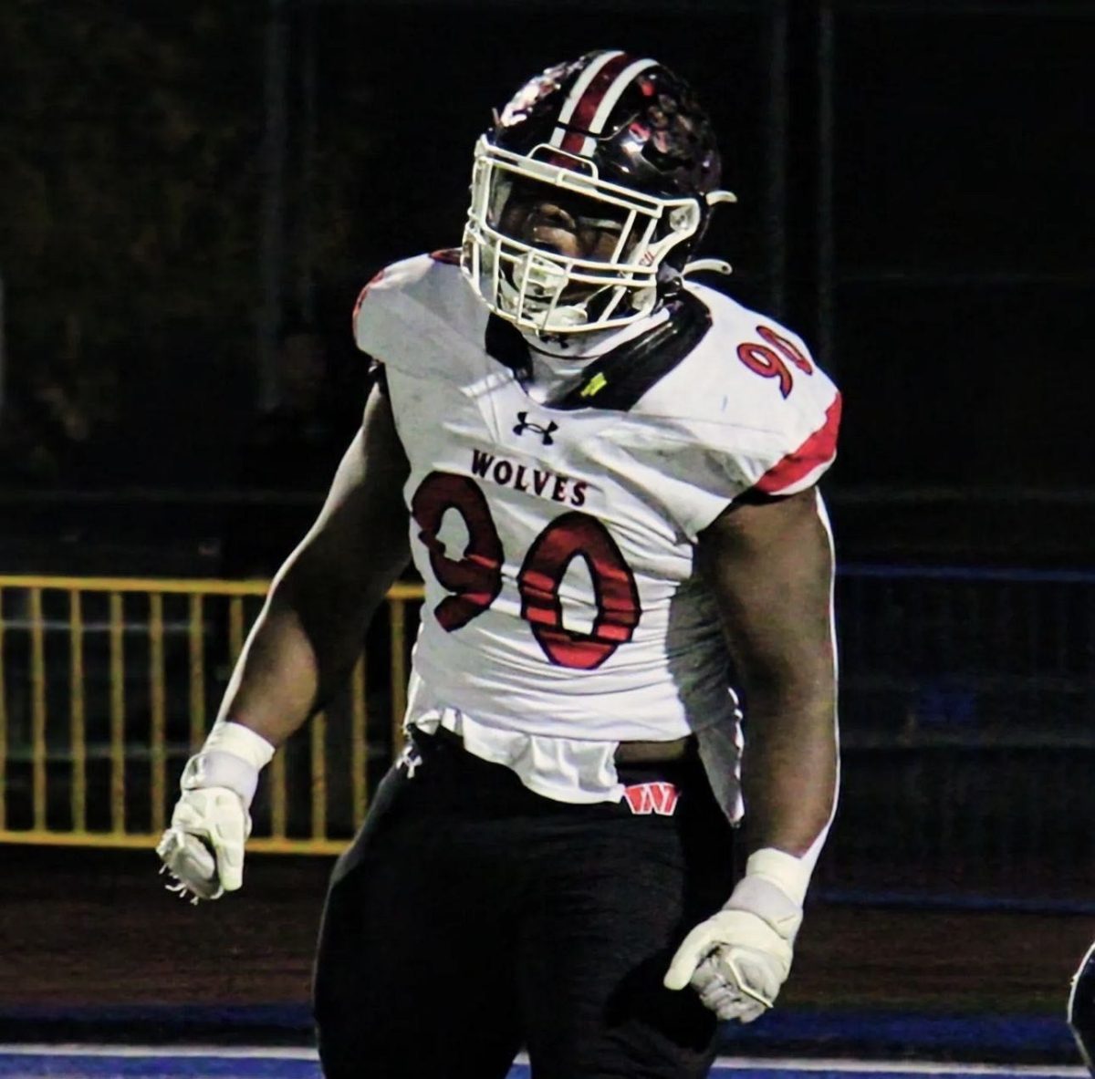 Emmanuel Olojo on the field during one of his football games, cheering for his tackle. 