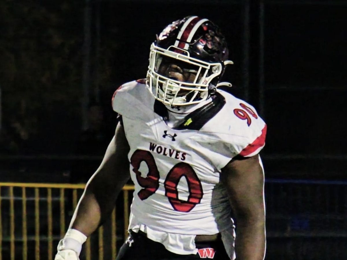 Emmanuel Olojo on the field during one of his football games, cheering for his tackle. 