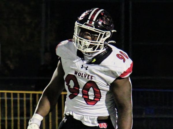 Emmanuel Olojo on the field during one of his football games, cheering for his tackle. 