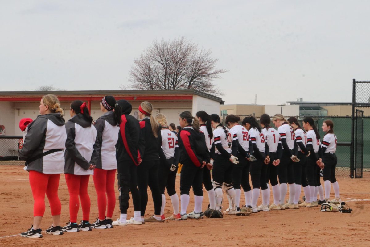 The Wolves stand on the foul ball line as the national anthem plays. 