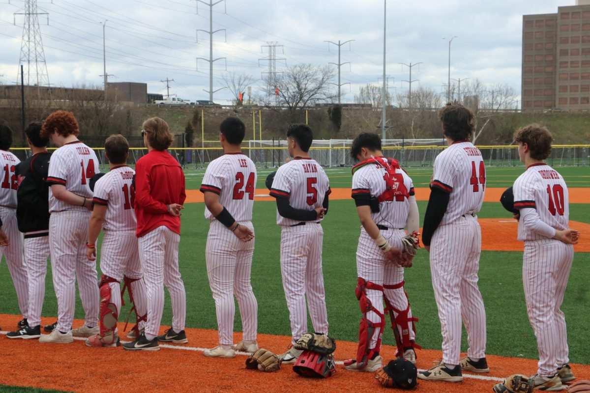 The boys are lined up for the playing of the national anthem. 