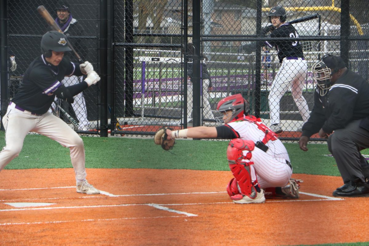 As a Wolf pitcher throws a pitch, senior Kheiron Jardinado reaches out his glove to catch the ball. 