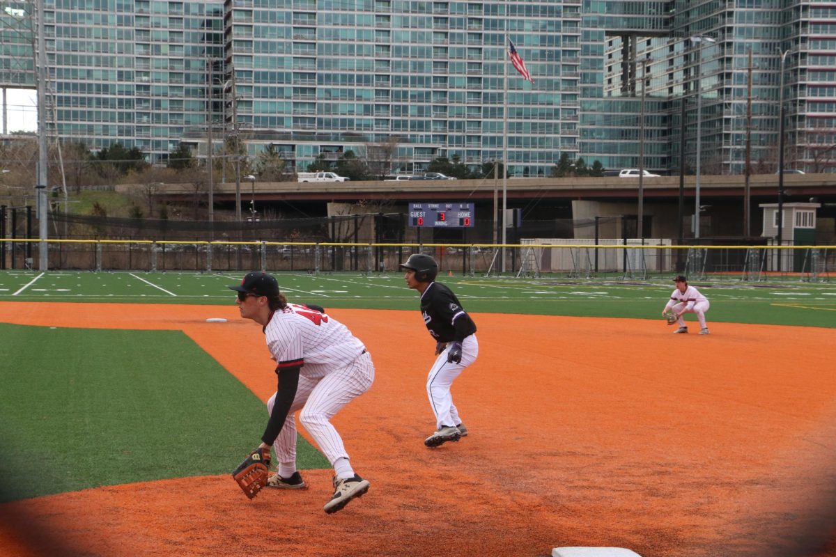 As a Viking player picks off at first base, Stewart and Ordower lower their gloves into the turf ready for the next ball. 