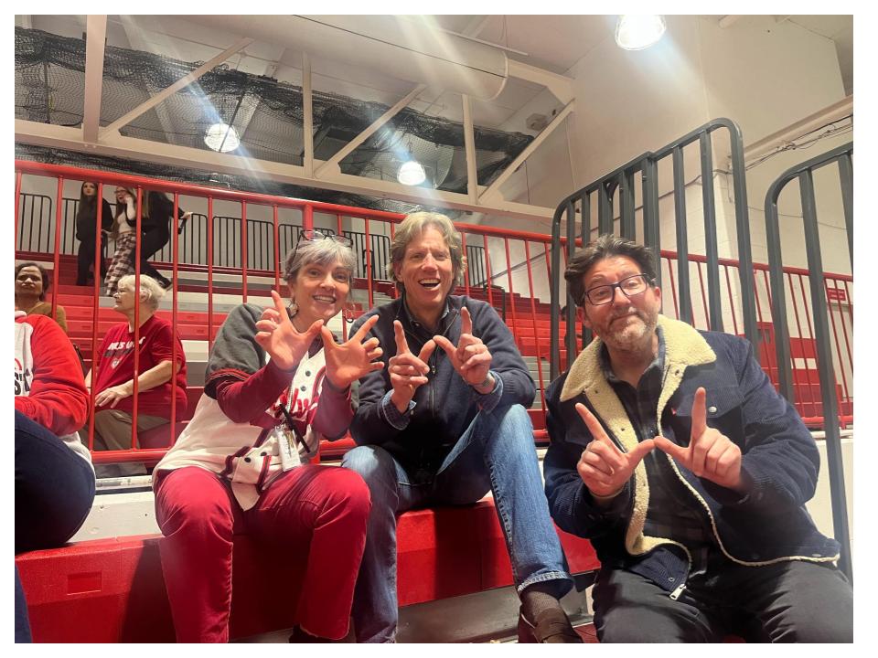 Blake Magnuson (center) attends a West girls basketball game during the 24-25 season with English teacher Michele Hettinger and English department director Michael Kucera.