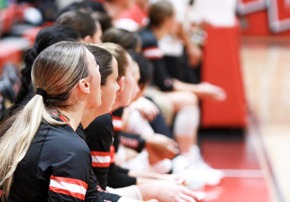 The Niles West Girls Varsity Volleyball tam, cheers on they're teammates from the sidelines.
