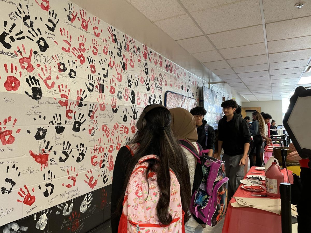 Seniors takes a look at the freshly painted handprint wall.
