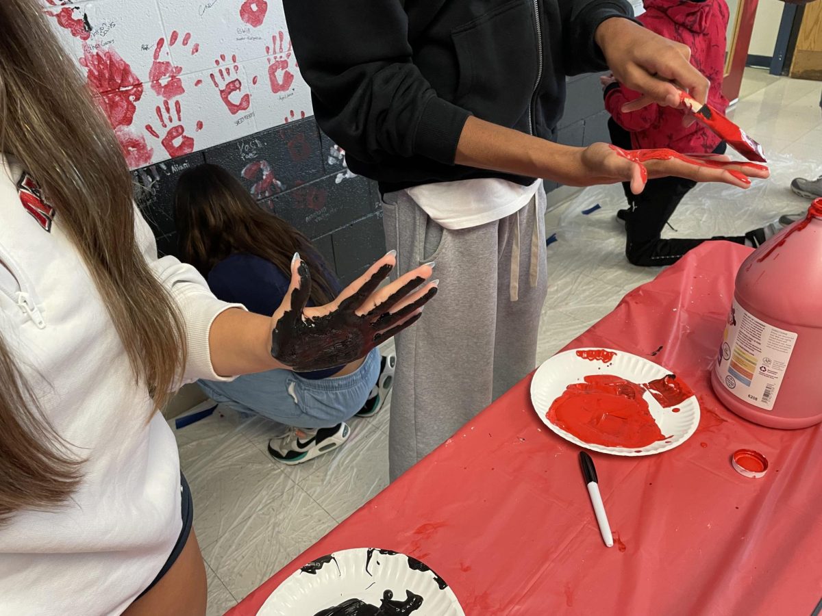 Red and black paints were set out in front of the senior alley wall in preparation for the handprints.
