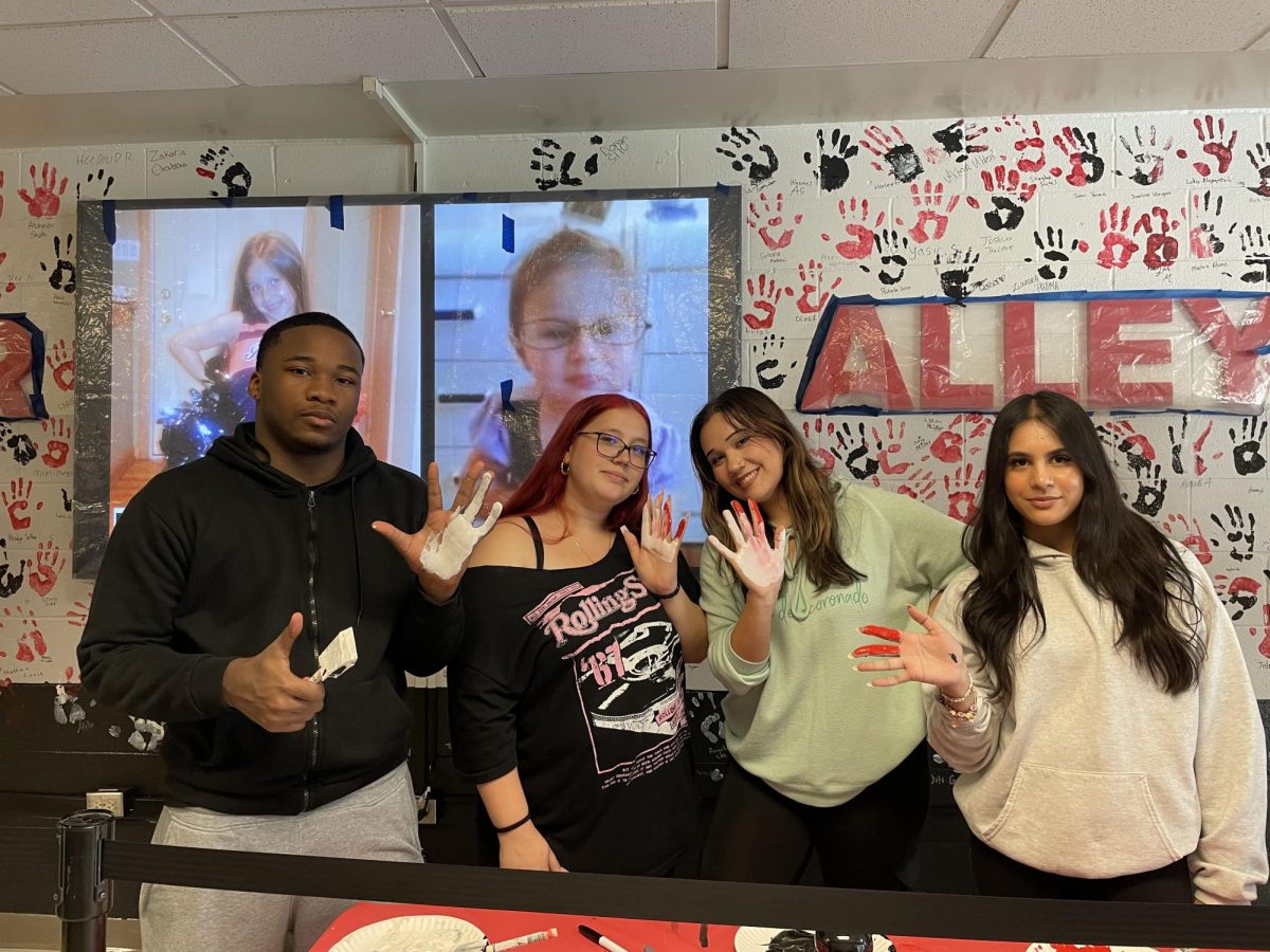 (Left to right) David Carmickle, Dahlia Pruyn, Tina Botonakis and Ariyanna Miah, seniors, gather to place their handprints on the wall.
