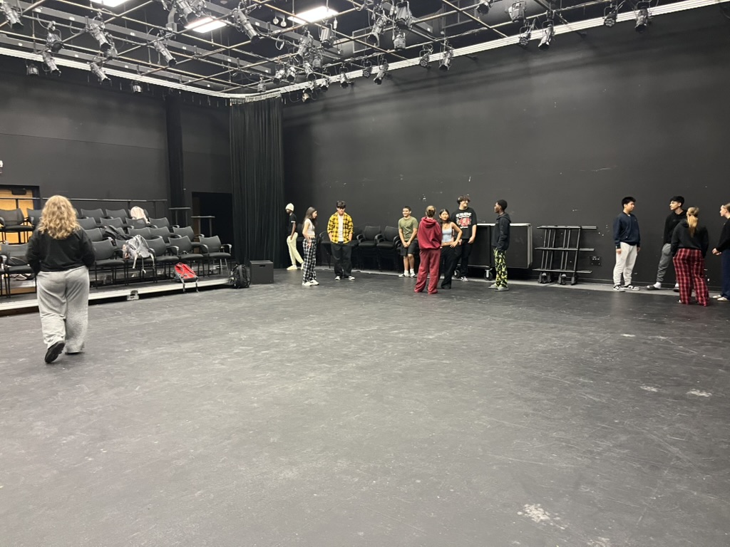 A public speaking class, theater workshop, does a group activity.
