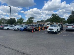 A rope tied around cones separates the students' spots from the staff parking lot.
