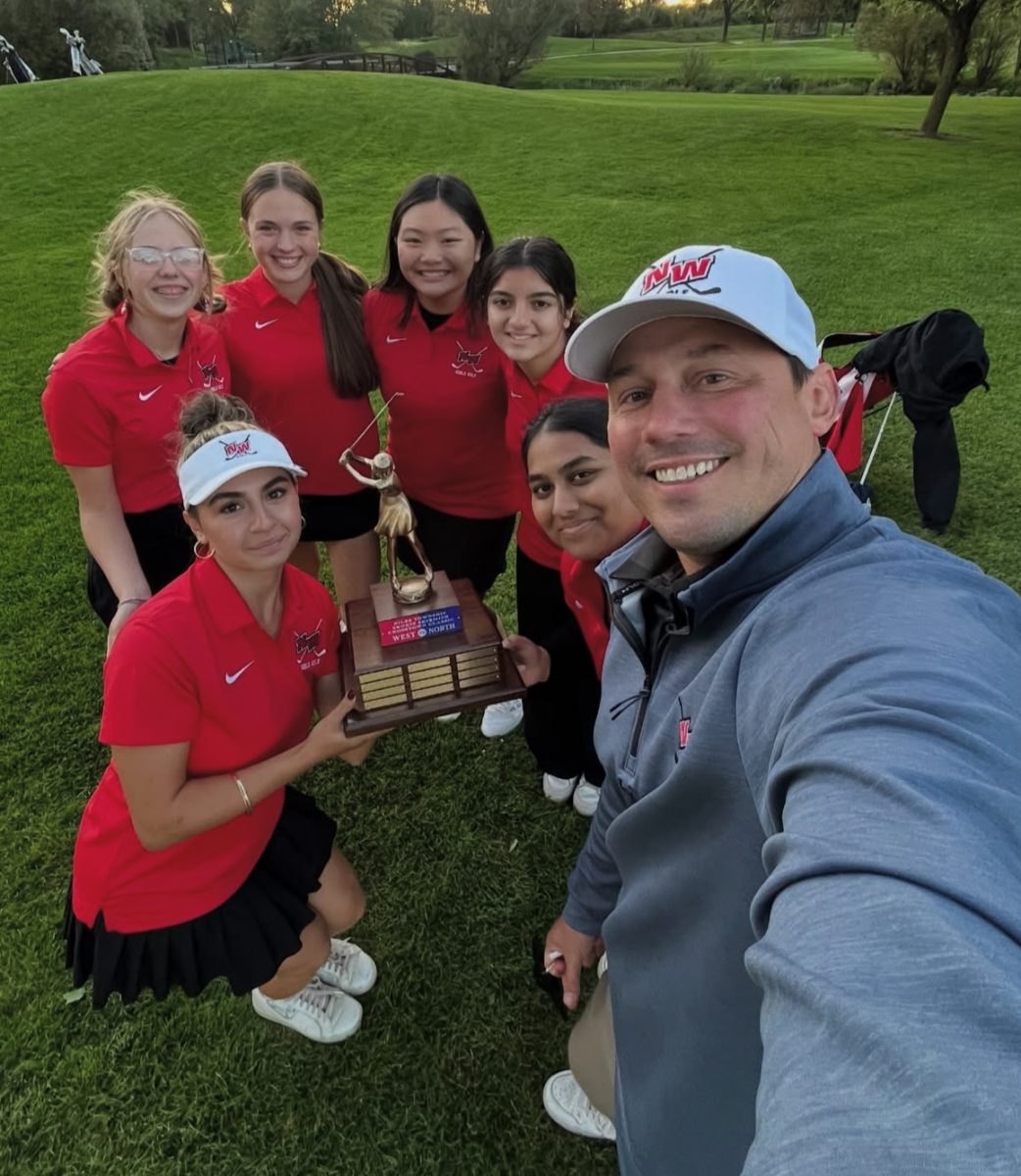 The girls varsity golf team and coach Daniel Larrabee pose with the Crosstown Classic trophy following their win against Niles North. Photo via @nileswestgirlsgolf on Instagram.