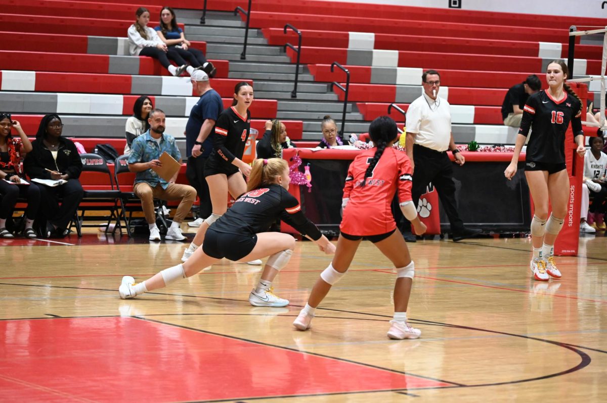 Claire Stewart, junior, begins to dive for the ball before it touches the ground to save the wolves from giving up a point. 