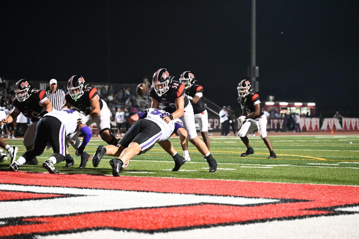 Senior Antonio Gomez pushes down the niles north defender making his block for senior nick west to run the ball. 