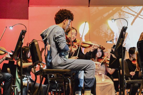 From left, juniors and first violinists Fabian Campos and Evy Kung play in the symphonic orchestra during the Candlelight Masquerade concert held in the auditorium on Thurs., Oct. 9.
