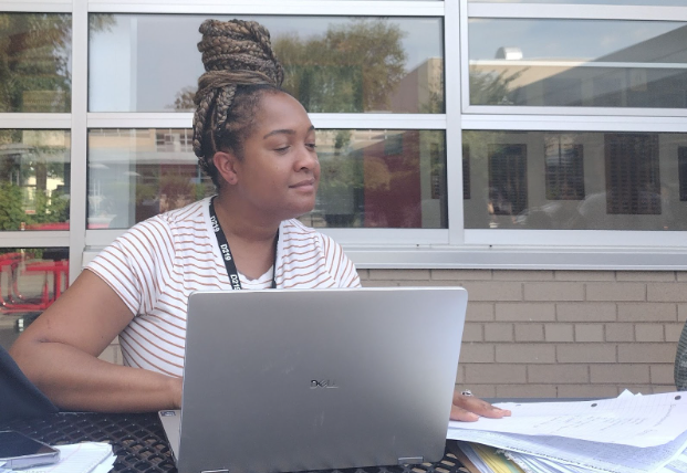 English teacher TeNesha Ukomadu works on grading assignment in the courtyard. 