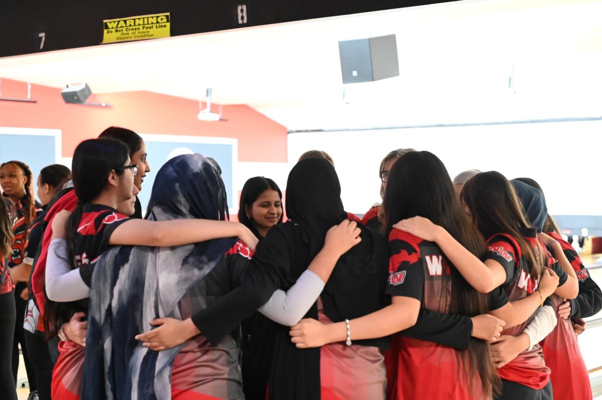 The girls bowling team goes into a huddle before their last home game and senior night. They faced Evanston Township High School on Jan. 8.
