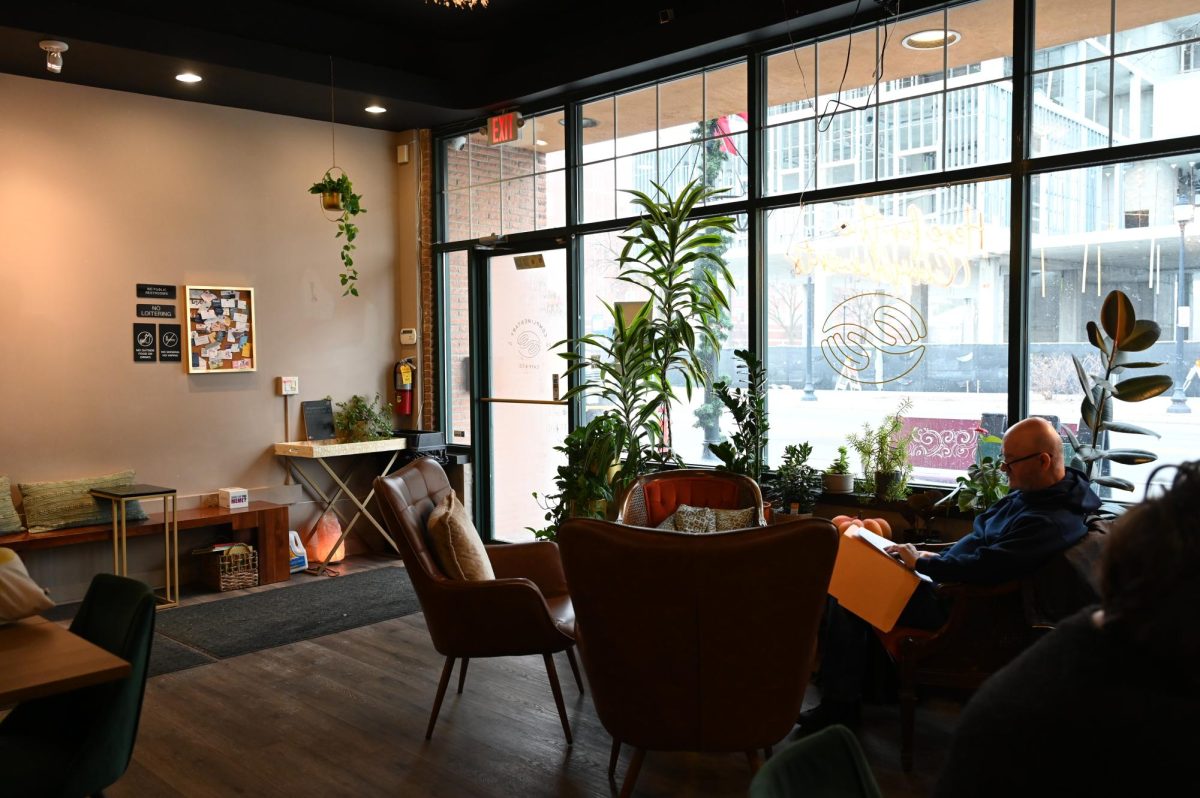 Seating and plants fill the interior of Complimentary Cafe, offering customers a quiet place to relax, work or meet with others.