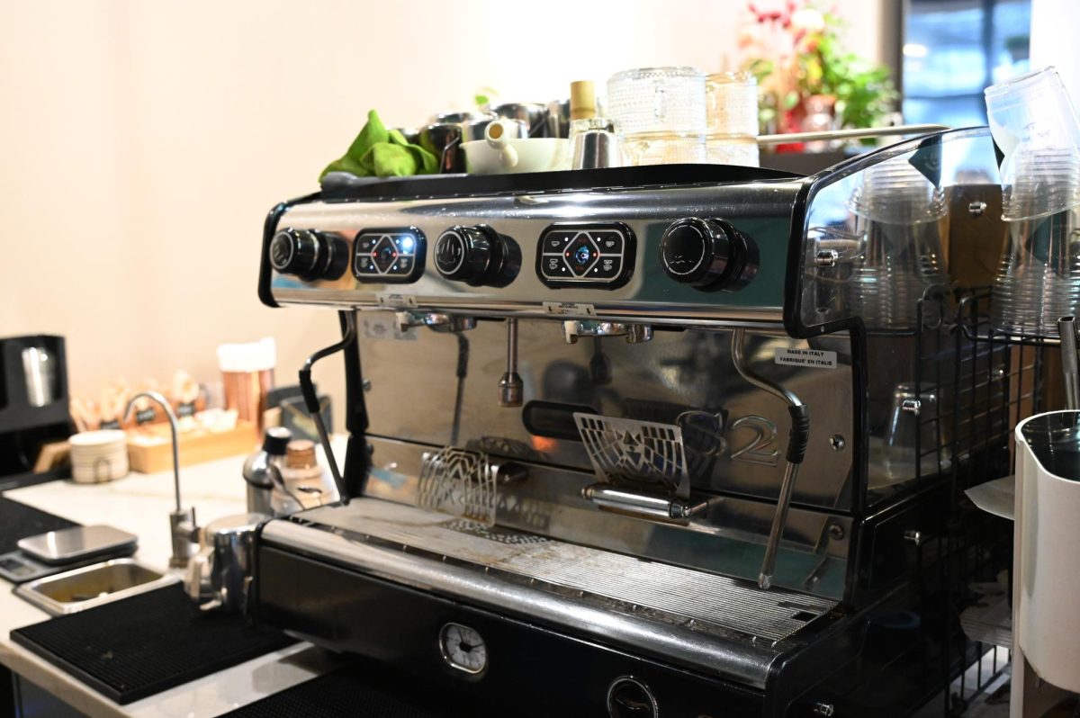 An espresso machine sits behind the counter where baristas prepare drinks for customers throughout the day.