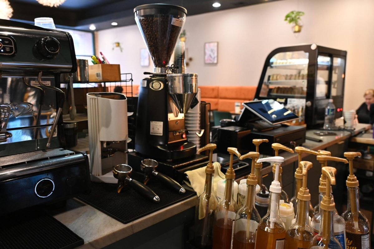 A coffee grinder, espresso machine and syrup station sit ready behind the counter, highlighting the behind-the-scenes work that goes into each drink