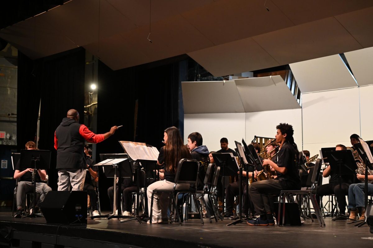 Band Director Justin Johnson orchestrates the band as they play "Thawing" and "Choose Joy" in front of the eighth-graders.