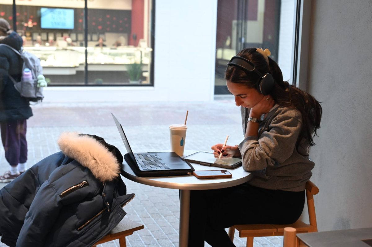 A customer spends their time studying at Blue Bottle while sipping on a drink.