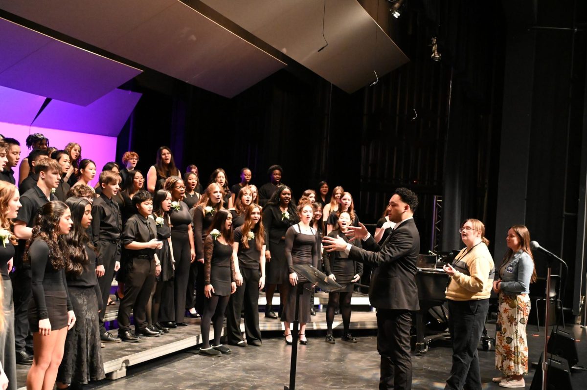 Choir Director Justin De La Cruz leads the voice drill before the concert starts.