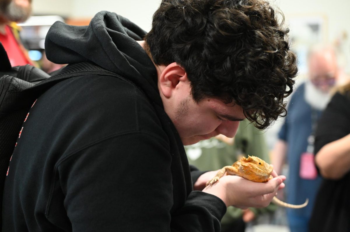 A student holds a bearded dragon after the event.