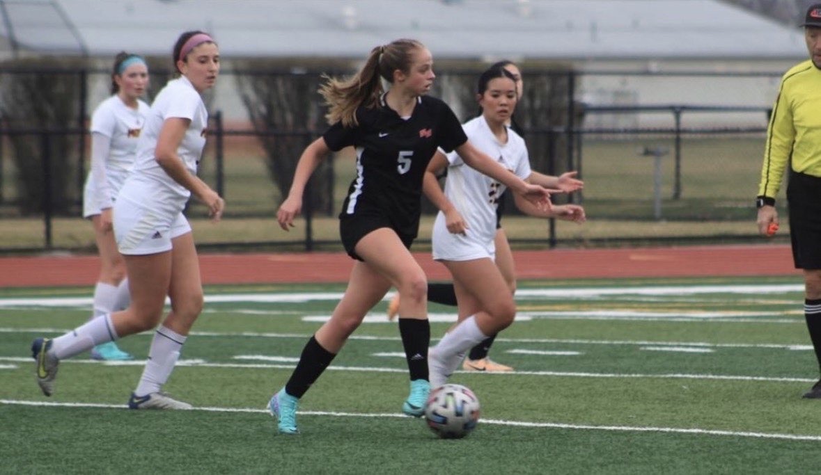Linnea Applequist, senior, dribbles the soccer ball up the field during a game. 
